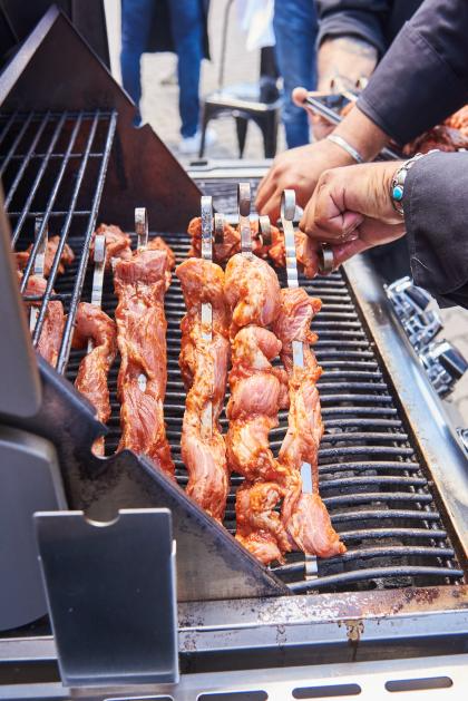 Zwei händen beim Grillen von Fleisch