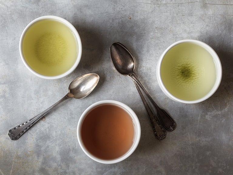 Tassen mit verschiedenem Tee von oben und Löffel