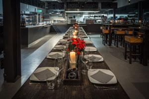 Italienische-Kueche-Blick - Langer Tisch mit Tellern in Profiküche