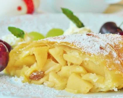 Apfelstrudel auf einem Teller mit Puderzucker angerichtet