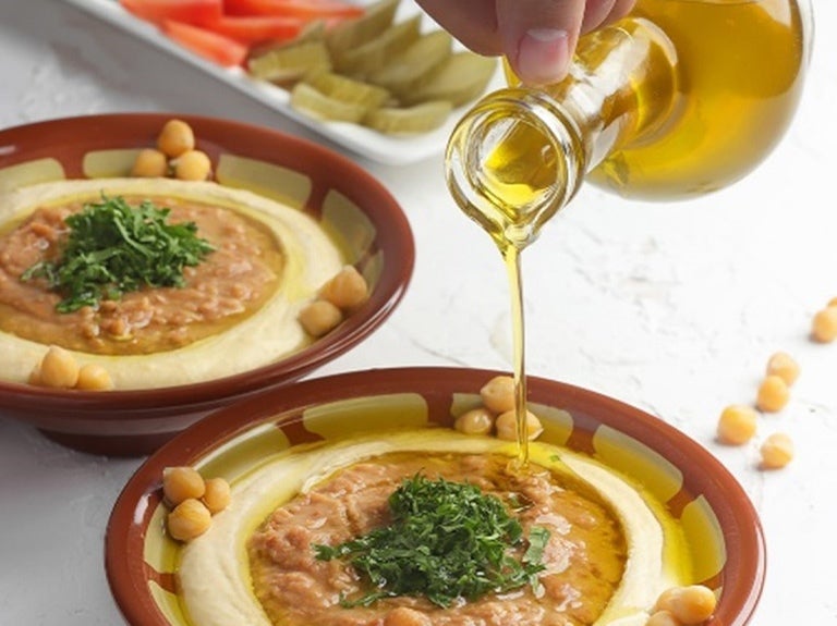Hummus wird mit Olivenöl versehen