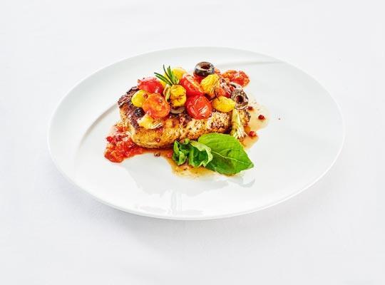 Kalbsrückensteak mit Rosmarin und rosa Beeren gegrillt mit schwarzen Oliven und Kirschtomaten