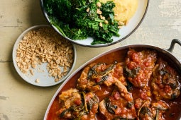Geschmorte Schweinekoteletts in Tomatensauce mit Salbei, frittierten Grünkohl und cremiger Polenta