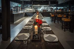 Italienische-Kueche-Blick - Langer Tisch mit Tellern in Profiküche