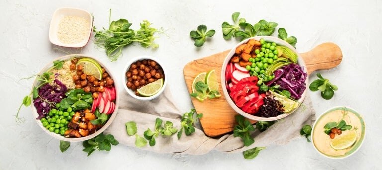 Leckere, farbenfrohe vegane Poke Bowl auf hellgrauem Hintergrund.
